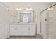 Well-lit bathroom with a double vanity, framed mirrors, and a tiled glass shower at 2212 Crosswind St, Fort Lupton, CO 80621