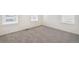 Bright bedroom with neutral gray carpet and natural light from three large windows at 2212 Crosswind St, Fort Lupton, CO 80621