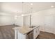 Open concept kitchen island with granite counter, stainless dishwasher, and lighting at 2212 Crosswind St, Fort Lupton, CO 80621