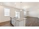 Kitchen island features granite countertop, stainless appliances, and ample natural light at 2212 Crosswind St, Fort Lupton, CO 80621
