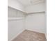 Compact walk-in closet with white shelving and neutral carpet flooring at 2212 Crosswind St, Fort Lupton, CO 80621