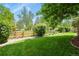 Lush backyard with a charming wooden fence, green lawn, and beautifully landscaped garden, perfect for outdoor enjoyment at 5755 W Berry Ave, Denver, CO 80123