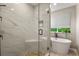 Updated bathroom featuring tile shower with bench, pebble floor, and freestanding tub by window at 5755 W Berry Ave, Denver, CO 80123