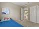 Cozy bedroom with plush carpet, blue bedding, a closet, and an open doorway leading to the upper level at 5755 W Berry Ave, Denver, CO 80123