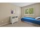Bright bedroom features neutral walls, carpet, and a bed under a window with wooded views at 5755 W Berry Ave, Denver, CO 80123