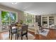 Bright dining room with glass table, four chairs, sliding glass doors to the deck and view of the living room at 5755 W Berry Ave, Denver, CO 80123