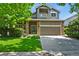 Charming two-story home with stone accents, a well-manicured lawn and a two car garage at 5755 W Berry Ave, Denver, CO 80123
