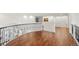 Bright hallway with hardwood floors, decorative railing and white walls and arched window detail at 73 Glenmoor Dr, Cherry Hills Village, CO 80113