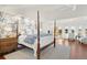 Spacious main bedroom with a four-poster bed, floral wallpaper, hardwood floors, and natural light from the windows at 73 Glenmoor Dr, Cherry Hills Village, CO 80113