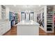 Spacious walk-in closet with custom shelving, a central island, and a decorative chandelier at 73 Glenmoor Dr, Cherry Hills Village, CO 80113