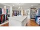 Expansive walk-in closet featuring custom shelves, central island, and abundant storage at 73 Glenmoor Dr, Cherry Hills Village, CO 80113