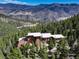 Stunning mountain home with modern design and stone accents nestled among lush green trees at 180 Outpost Ln, Evergreen, CO 80439
