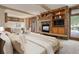 Inviting living room with a stone fireplace, built-in shelves, and views of the beautiful outdoor scenery at 180 Outpost Ln, Evergreen, CO 80439