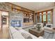 Inviting living room features a stone fireplace, built-in shelving, and sliding doors to the outdoors at 180 Outpost Ln, Evergreen, CO 80439