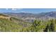 Stunning mountain view with rolling hills and evergreen trees under a clear blue sky at 180 Outpost Ln, Evergreen, CO 80439