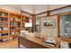 Bright home office with custom built-in bookshelves and natural light from multiple windows at 180 Outpost Ln, Evergreen, CO 80439