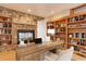 Inviting home office with a stone fireplace, custom shelves, and ample workspace at 180 Outpost Ln, Evergreen, CO 80439