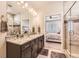 This bathroom offers a granite countertop with double sinks and glass enclosed shower next to the bedroom at 476 Silver Rock Trl, Castle Rock, CO 80104