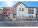 Charming townhome featuring stone accents, fenced yard, and a combination of red and gray siding at 2839 E 103Rd Dr, Thornton, CO 80229