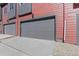 Two car garage door painted gray with a matching gray trim and red siding above at 2839 E 103Rd Dr, Thornton, CO 80229