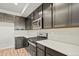 A modern kitchen features dark cabinets, stainless steel appliances, and white herringbone backsplash at 2839 E 103Rd Dr, Thornton, CO 80229