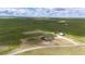 Expansive aerial view of property and horse training circle, with a house, barn and green pastures at 6201 S Vanderhoof St, Bennett, CO 80102