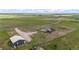 Aerial shot of back of house and additional outbuildings, including horse shelters on acreage at 6201 S Vanderhoof St, Bennett, CO 80102