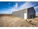 Large, metal barn on a property, featuring a sliding door, offering ample storage, situated on an expansive lot at 6201 S Vanderhoof St, Bennett, CO 80102