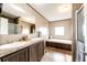 The bathroom has a double vanity, tub, shower, and hardwood floor at 6201 S Vanderhoof St, Bennett, CO 80102