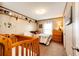 This bedroom features a crib, bed with bedding, shelves, dresser, and a light at 6201 S Vanderhoof St, Bennett, CO 80102