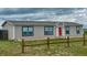 Inviting exterior showcasing a cozy home with a red front door and a rustic wooden fence at 6201 S Vanderhoof St, Bennett, CO 80102