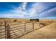 A fenced horse lot under a bright sky features two horses and a storage building for supplies at 6201 S Vanderhoof St, Bennett, CO 80102