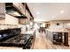 Open kitchen with wooden cabinets, large island, modern appliances and hardwood flooring at 6201 S Vanderhoof St, Bennett, CO 80102