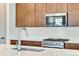 Modern kitchen with stainless steel appliances, white countertops and backsplash, and wood cabinets at 24593 E 34Th Ave, Aurora, CO 80019