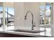 Close up of new kitchen faucet, sink, and countertops, with an outside neighborhood view through the windows at 24593 E 34Th Ave, Aurora, CO 80019
