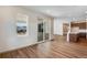 Open-concept living room featuring wood-look floors, access to the kitchen, and a sliding glass door at 24593 E 34Th Ave, Aurora, CO 80019