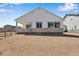 Back of house with white siding, stone accents, large windows, and an unfinished yard at 24593 E 34Th Ave, Aurora, CO 80019