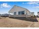 Back of house with white siding, stone accents, large windows, and an unfinished yard at 24593 E 34Th Ave, Aurora, CO 80019