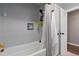 Tiled tub/shower combo with toiletry shelves, towel rack, and a modern shower curtain at 270 S Chase St, Lakewood, CO 80226