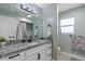 Bright bathroom with modern vanity, granite countertop, and a shower with gray tile at 270 S Chase St, Lakewood, CO 80226