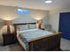 Well-lit bedroom with a wooden bed frame, soft carpet, and a cozy seating area by the blue door at 270 S Chase St, Lakewood, CO 80226