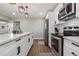 Modern kitchen with white cabinets, stainless steel appliances, and stylish pendant lighting at 270 S Chase St, Lakewood, CO 80226