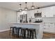 Kitchen island with seating, stainless steel appliances, and white cabinets at 270 S Chase St, Lakewood, CO 80226