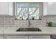 Kitchen sink and window with white subway tile backsplash at 270 S Chase St, Lakewood, CO 80226
