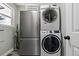 Compact laundry space featuring stacked washer/dryer and refrigerator at 270 S Chase St, Lakewood, CO 80226