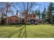 Large brick home with a spacious backyard and lush green lawn and mature trees at 29 Viking Dr, Cherry Hills Village, CO 80113