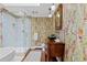 Luxurious bathroom with colorful wallpaper, decorative mirror, glass shower and marble floors at 29 Viking Dr, Cherry Hills Village, CO 80113