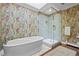 Stunning bathroom features standalone tub, glass enclosed shower, and unique patterned wallpaper at 29 Viking Dr, Cherry Hills Village, CO 80113