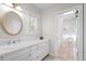 Well-lit bathroom featuring white vanity with sink and an adjacent full bathroom view at 29 Viking Dr, Cherry Hills Village, CO 80113