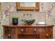 Vintage bathroom vanity with bowl sink, unique fixtures, mosaic backsplash and patterned wallpaper at 29 Viking Dr, Cherry Hills Village, CO 80113
